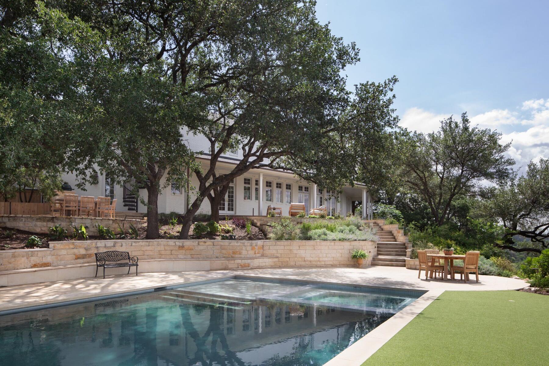 Back exterior with pool and live oaks