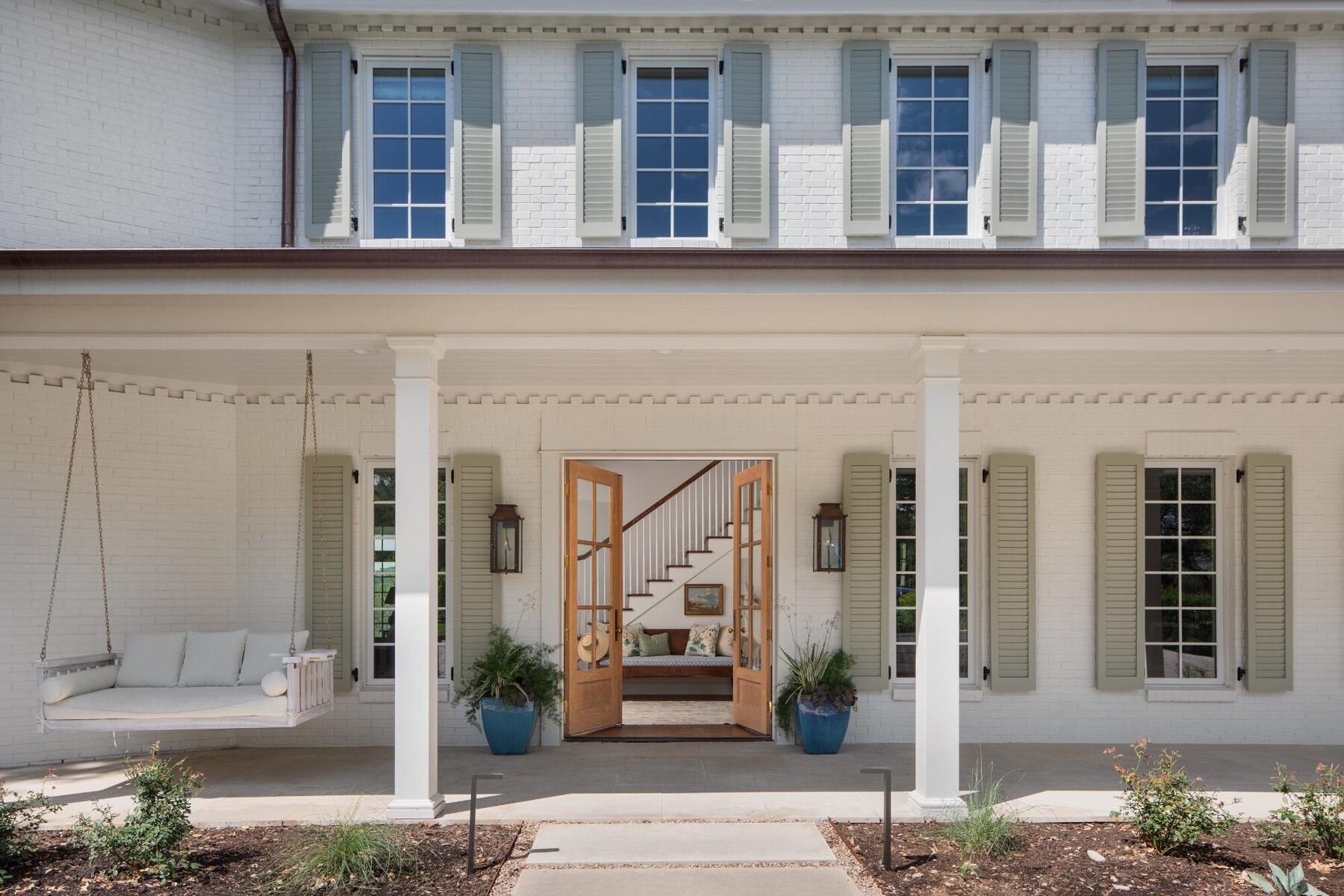 Front porch with porch swing and open entry doors